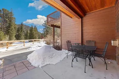 a patio with a table and chairs on a house at Bugle Pointe B04 by Estes Park Condos in Estes Park
