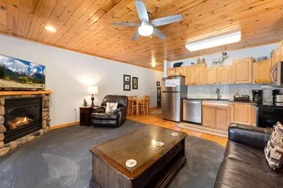 a living room with a fireplace and a kitchen at Bugle Pointe B04 by Estes Park Condos in Estes Park