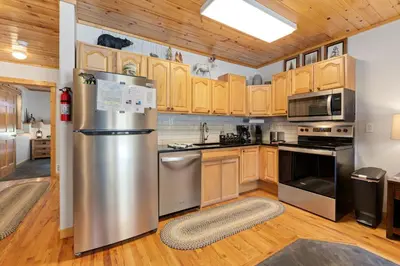 a kitchen with stainless steel appliances and wooden cabinets at Bugle Pointe B04 by Estes Park Condos in Estes Park