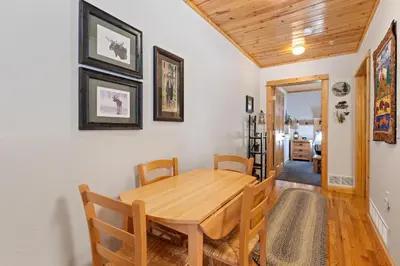 a dining room with a wooden table and chairs at Bugle Pointe B04 by Estes Park Condos in Estes Park