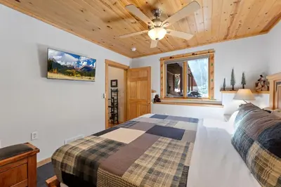 a bedroom with a bed and a ceiling fan at Bugle Pointe B04 by Estes Park Condos in Estes Park