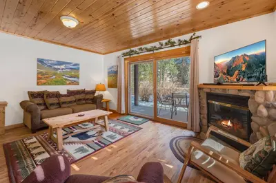 a living room with a fireplace and a tv at Bugle Pointe B06 by Estes Park Condos in Estes Park