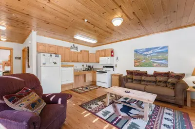 a kitchen and living room with a couch and a table at Bugle Pointe B06 by Estes Park Condos in Estes Park