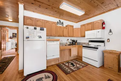 a kitchen with white appliances and wooden cabinets at Bugle Pointe B06 by Estes Park Condos in Estes Park