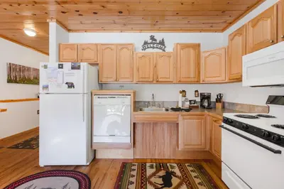 a kitchen with white appliances and wooden cabinets at Bugle Pointe B06 by Estes Park Condos in Estes Park
