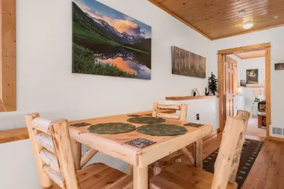 a dining room with a wooden table and chairs at Bugle Pointe B06 by Estes Park Condos in Estes Park
