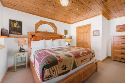 a bedroom with a bed and a wooden ceiling at Bugle Pointe B06 by Estes Park Condos in Estes Park