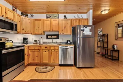 a kitchen with wooden cabinets and a stainless steel refrigerator at Bugle Pointe B16 by Estes Park Condos in Estes Park