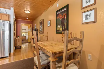 a dining room with a table and a refrigerator at Bugle Pointe B16 by Estes Park Condos in Estes Park