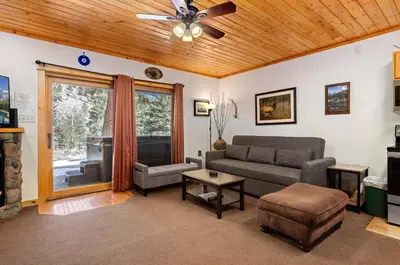 a living room with a couch and a piano at Bugle Pointe B16 by Estes Park Condos in Estes Park
