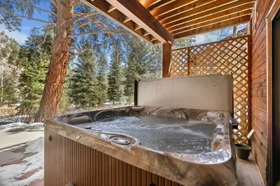 a jacuzzi tub in the backyard of a house at Bugle Pointe B16 by Estes Park Condos in Estes Park