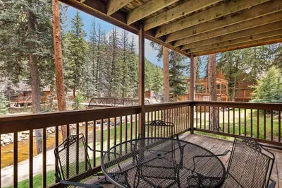 a screened porch with a table and chairs on it at Creekside Suites 16 by Estes Park Condos in Estes Park