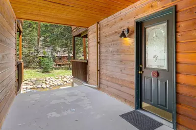 a wooden house with a door and a patio at Creekside Suites 16 by Estes Park Condos in Estes Park