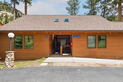 a house with a garage with a door open at Creekside Suites 16 by Estes Park Condos in Estes Park