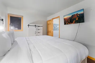 a white bedroom with a large white bed at Creekside Suites 16 by Estes Park Condos in Estes Park