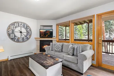 a living room with a couch and a clock on the wall at Creekside Suites 16 by Estes Park Condos in Estes Park