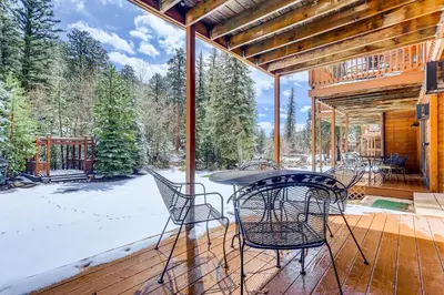 a patio with a table and chairs on a deck at Creekside Suites 01 by Estes Park Condos in Estes Park
