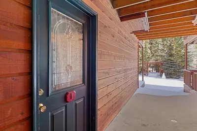 a door to a house with a wooden wall at Creekside Suites 01 by Estes Park Condos in Estes Park