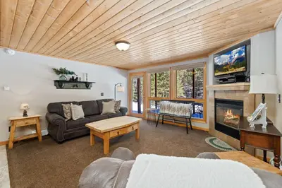a living room with a couch and a fireplace at Creekside Suites 01 by Estes Park Condos in Estes Park