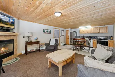 a living room with a fireplace and a table at Creekside Suites 01 by Estes Park Condos in Estes Park