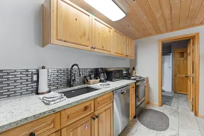 a kitchen with wooden cabinets and a sink at Creekside Suites 01 by Estes Park Condos in Estes Park