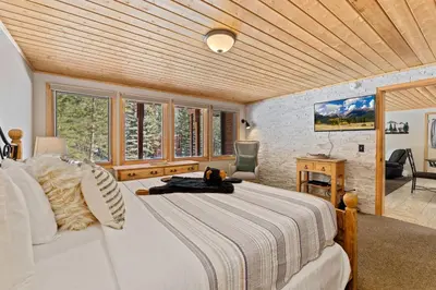a bedroom with a bed in a room with windows at Creekside Suites 01 by Estes Park Condos in Estes Park