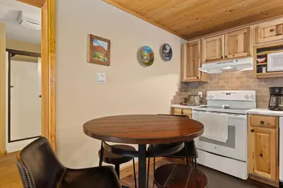 a small kitchen with a table and a stove at Creekside Suites 06 by Estes Park Condos in Estes Park