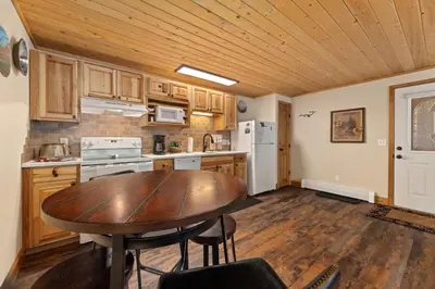 a kitchen with a wooden table and a wooden ceiling at Creekside Suites 06 by Estes Park Condos in Estes Park