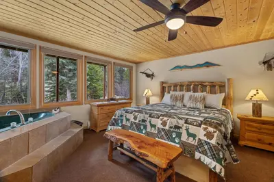a bedroom with a bed and a bath tub at Creekside Suites 06 by Estes Park Condos in Estes Park