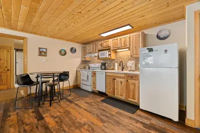 a kitchen with a white refrigerator and a table at Creekside Suites 06 by Estes Park Condos in Estes Park