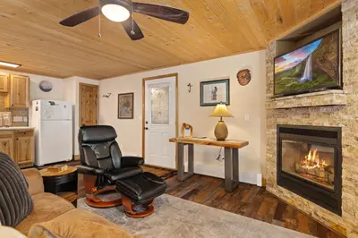 a living room with a fireplace and a chair at Creekside Suites 06 by Estes Park Condos in Estes Park