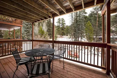 a patio with a table and chairs on a deck at Creekside Suites 12 by Estes Park Condos in Estes Park