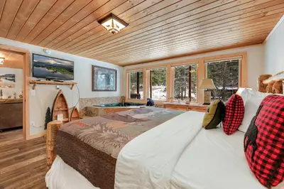 a bedroom with a large bed in a room with windows at Creekside Suites 12 by Estes Park Condos in Estes Park