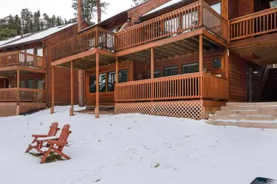 a wooden house with a bench in the snow at Creekside Suites 12 by Estes Park Condos in Estes Park