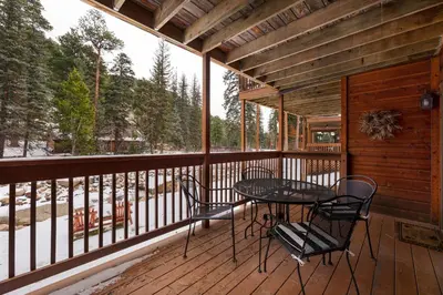 a patio with a table and chairs on a deck at Creekside Suites 12 by Estes Park Condos in Estes Park