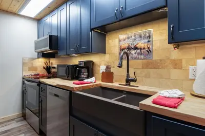 a kitchen with a stainless steel sink and blue cabinets at Creekside Suites 12 by Estes Park Condos in Estes Park