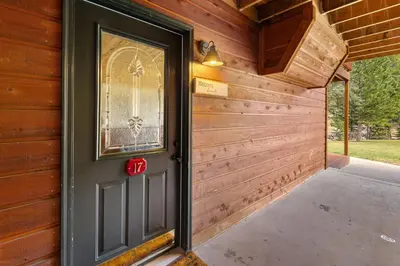a door in a wooden house with a porch at Creekside Suites 17 by Estes Park Condos in Estes Park