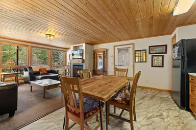 a kitchen and living room with a wooden ceiling at Creekside Suites 17 by Estes Park Condos in Estes Park