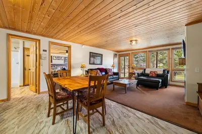 a dining room and living room with a wooden ceiling at Creekside Suites 17 by Estes Park Condos in Estes Park