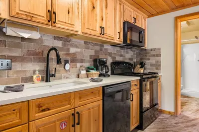 a kitchen with wooden cabinets and a sink at Creekside Suites 17 by Estes Park Condos in Estes Park