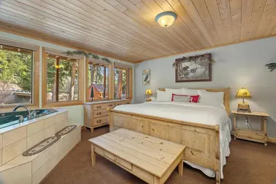 a bedroom with a bed and a tub and a sink at Creekside Suites 22 by Estes Park Condos in Estes Park