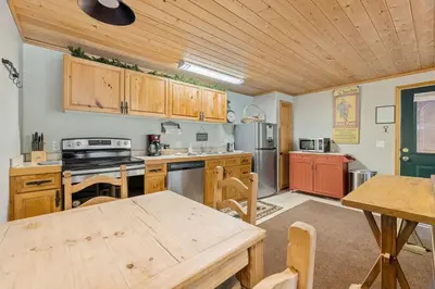 a kitchen with wooden cabinets and a wooden table at Creekside Suites 22 by Estes Park Condos in Estes Park