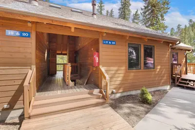 a log cabin with a porch and a deck at Creekside Suites 22 by Estes Park Condos in Estes Park