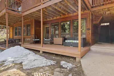 a log cabin with a porch with glass windows at Creekside Suites 22 by Estes Park Condos in Estes Park
