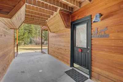a wooden house with a black door on a wall at Creekside Suites 22 by Estes Park Condos in Estes Park