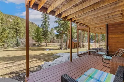 a wooden deck with a table and chairs on it at Creekside Suites 22 by Estes Park Condos in Estes Park