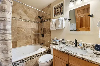 a bathroom with a tub and a toilet and a sink at Creekside Suites 03 by Estes Park Condos in Estes Park