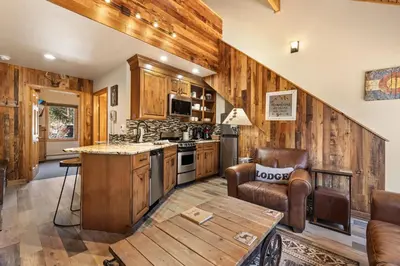 a kitchen with wooden walls and a table and chairs at Creekside Suites 03 by Estes Park Condos in Estes Park
