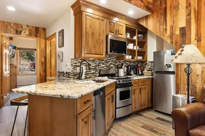 a kitchen with wooden cabinets and stainless steel appliances at Creekside Suites 03 by Estes Park Condos in Estes Park