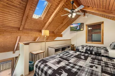 two beds in a room with a wooden ceiling at Creekside Suites 03 by Estes Park Condos in Estes Park